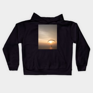 Paragliding over the ocean while golden sunset Kids Hoodie